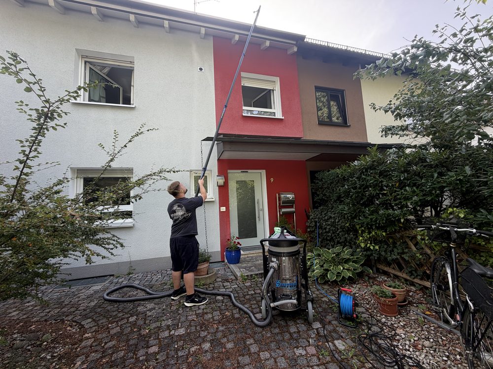 Julian Hilbig reinigt eine Dachrinne mit Carbon-Absaugstange und Industriesauger